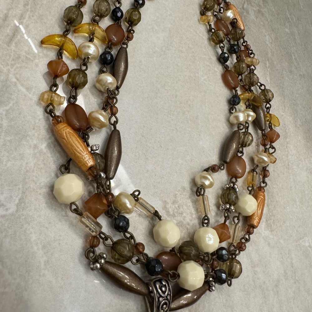 Multi-strand beaded necklace with a touch of brown and green hues. - Picture 3 of 7